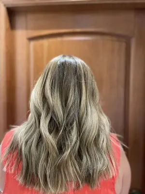 Honey blonde balayage on shoulder-length wavy hair