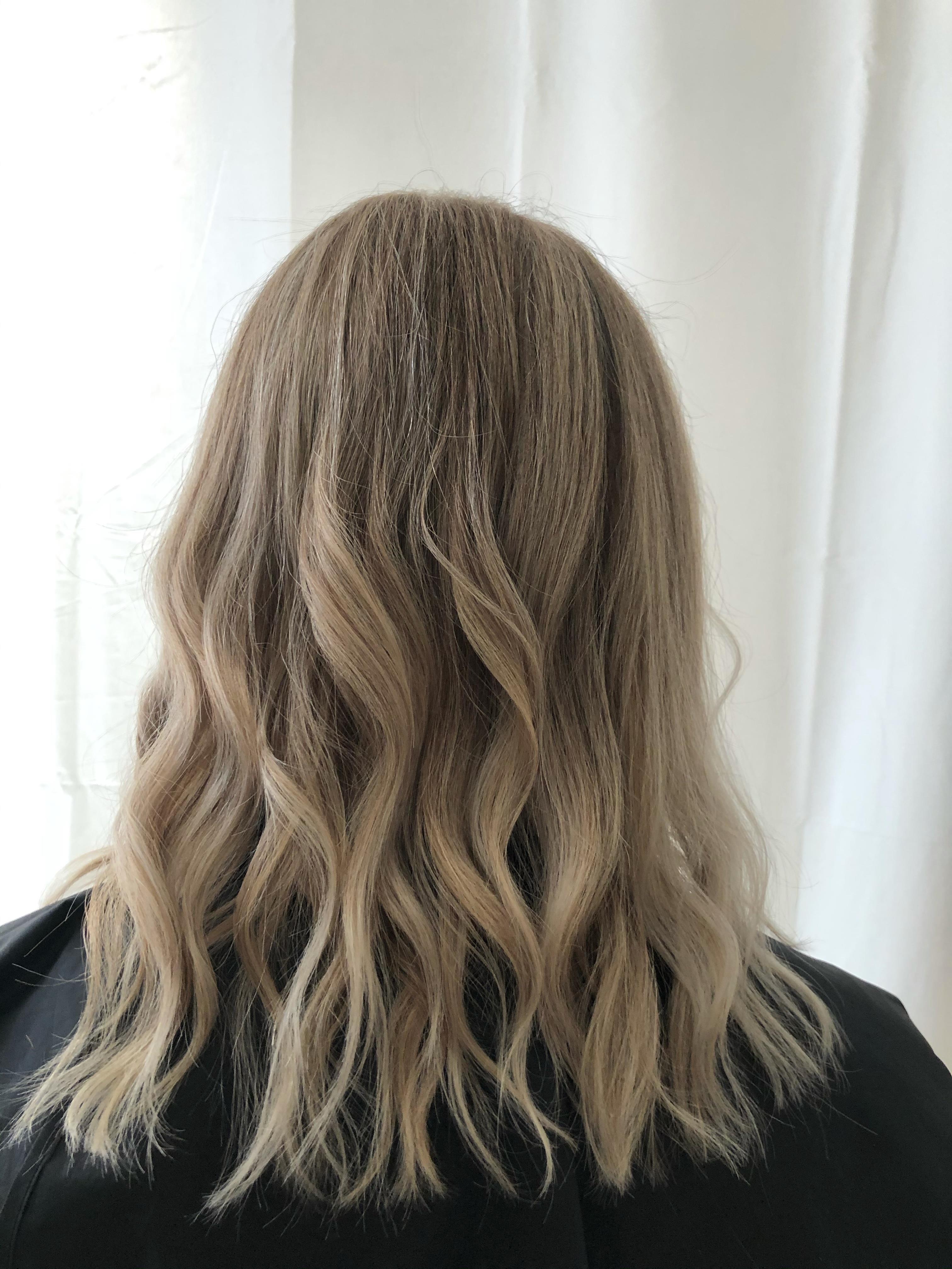 Long dimensional blonde hair styled in loose waves